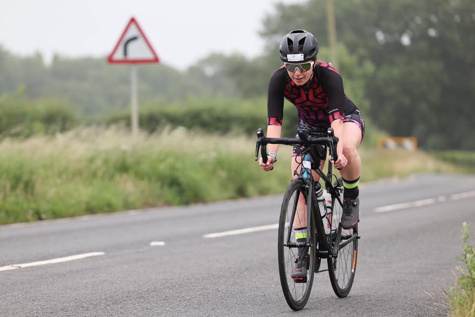 A Blackzone Coaching athlete cycling on a road