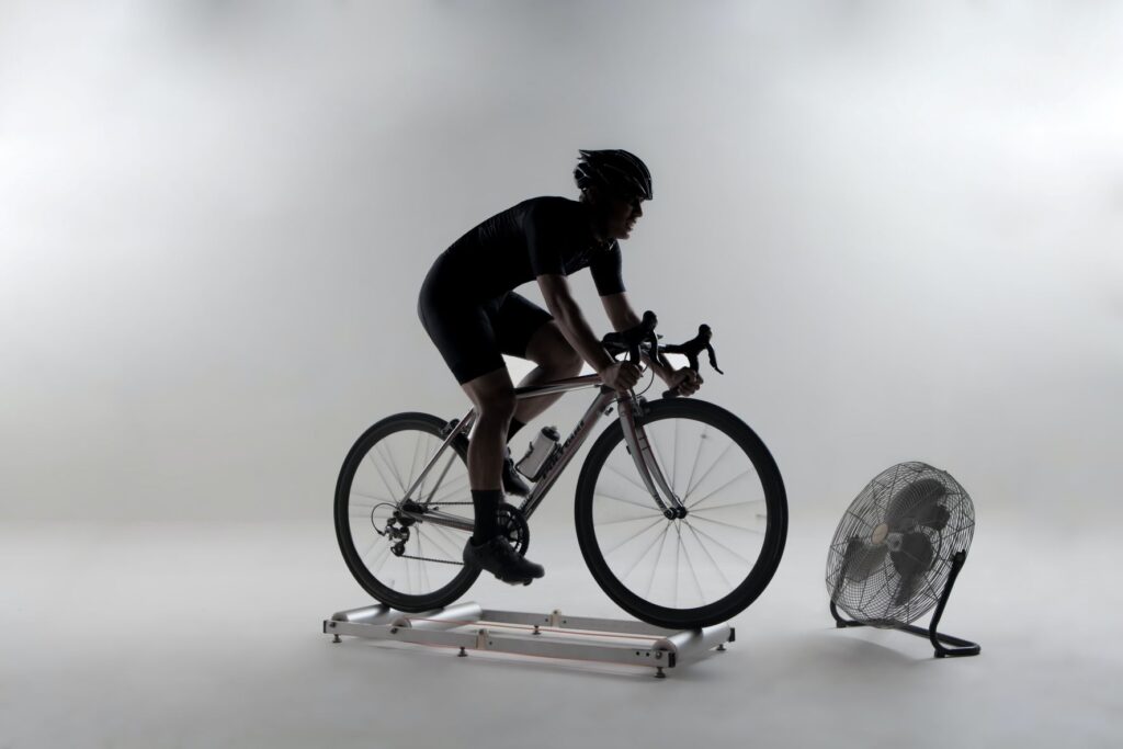 A person riding a bicycle on rollers indoors