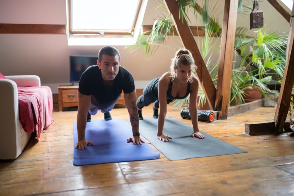 two people are stretching while on yoga mats